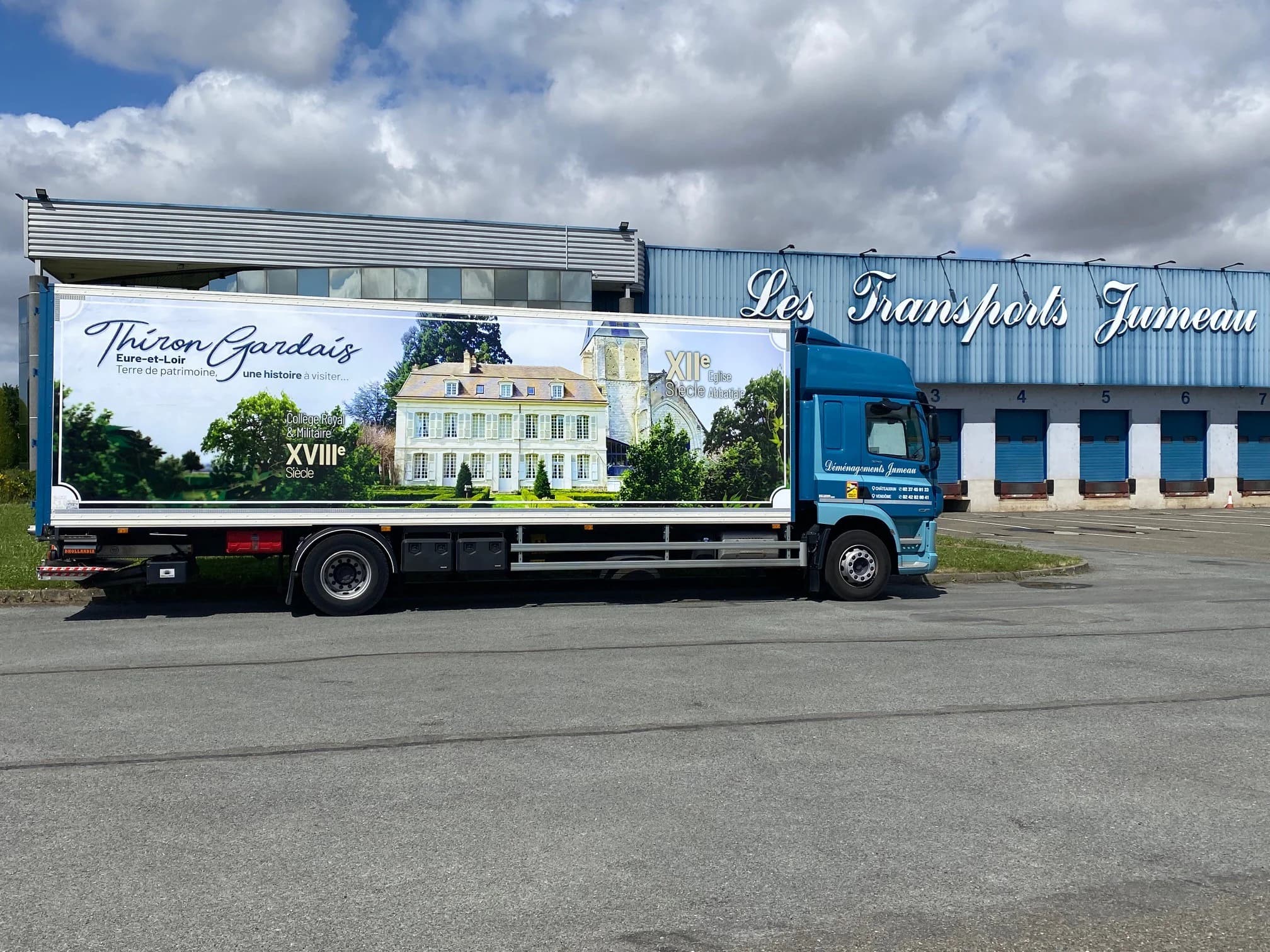Un camion des Déménagements Jumeau, à la caisse peinte de Thiron-Gardais, devant le bâtiment des Transports Jumeau