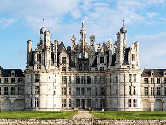 Le château de Chambord, sa façade blanche et ses toits hérissés de cheminées et de lanternons