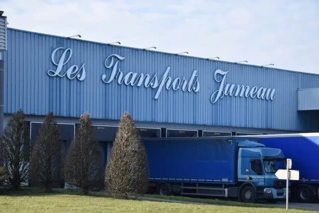 Le bâtiment des Transports Jumeau, des semi-remorques bâchées à quai