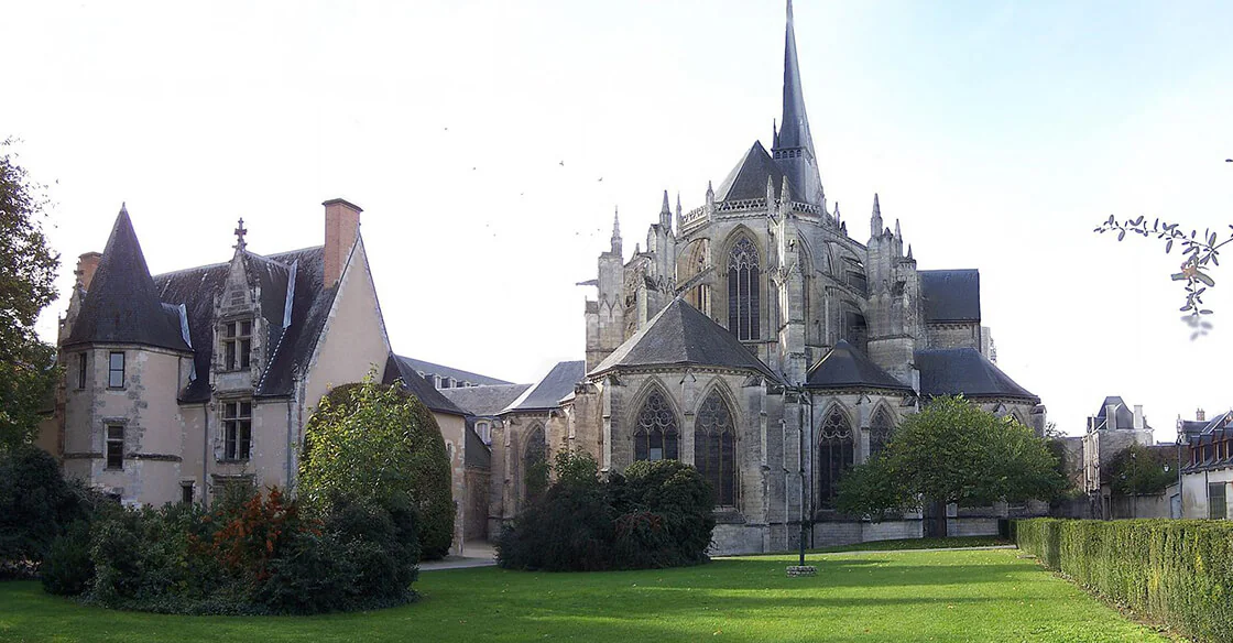 L’abbaye de la Trinité de Vendôme, son chevet gothique et un clocher à flèche, vue depuis une pelouse