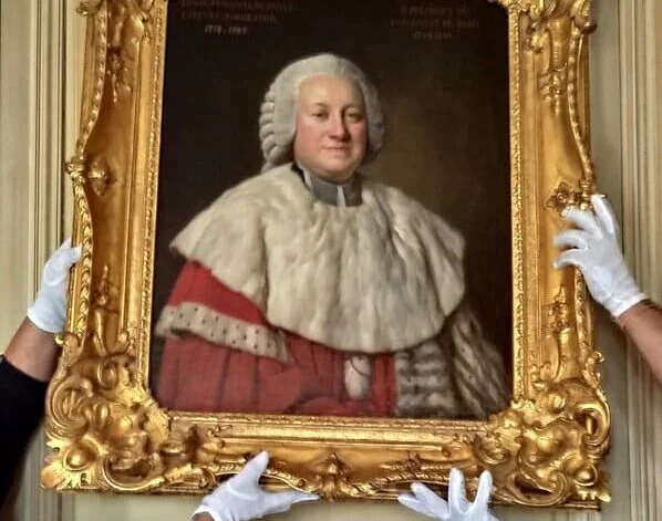 Des mains en gants blancs tiennent un portrait ancien dans son cadre doré sculpté