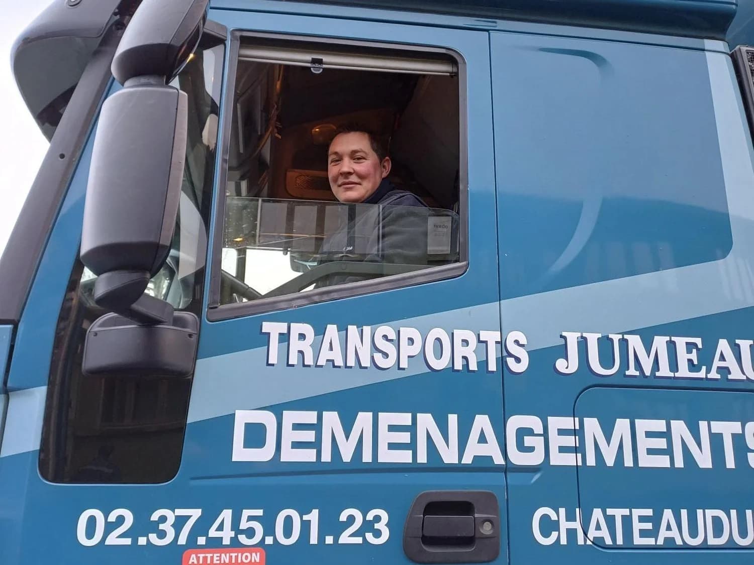 La cabine d’un camion des Transports Jumeau de Châteaudun, son chauffeur à la portière