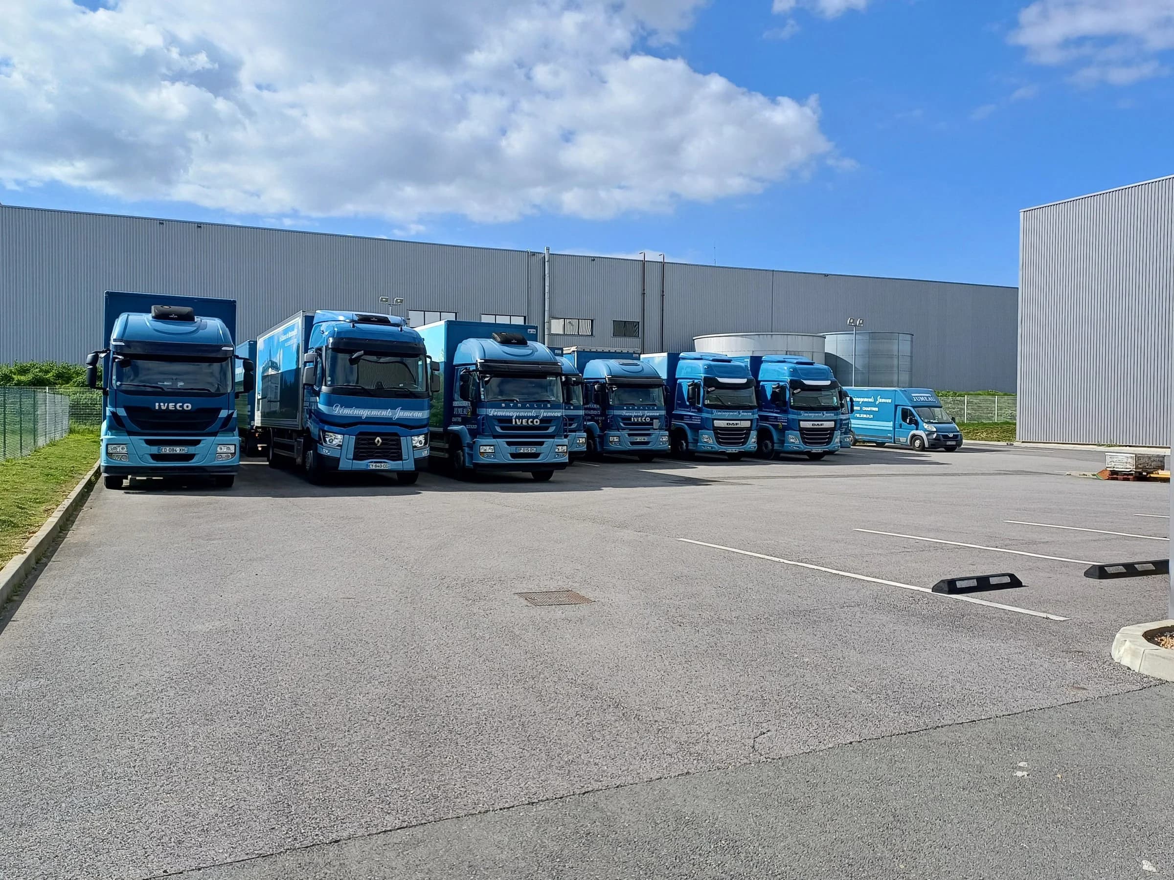 Les camions bleus de Jumeau alignés devant un entrepôt de l’entreprise, à Gellainville